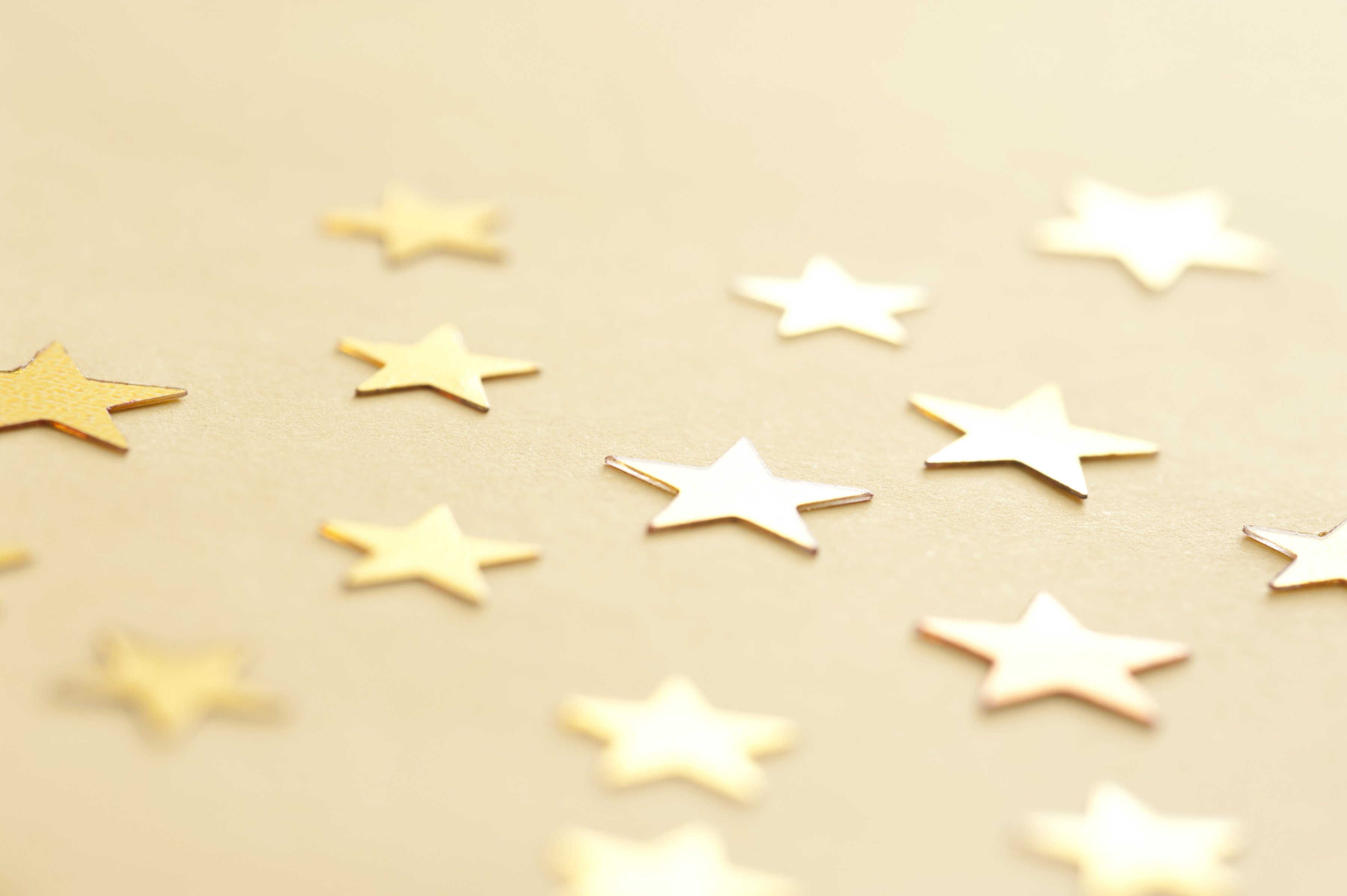 Gold Stars Scattered on Neutral Background Free