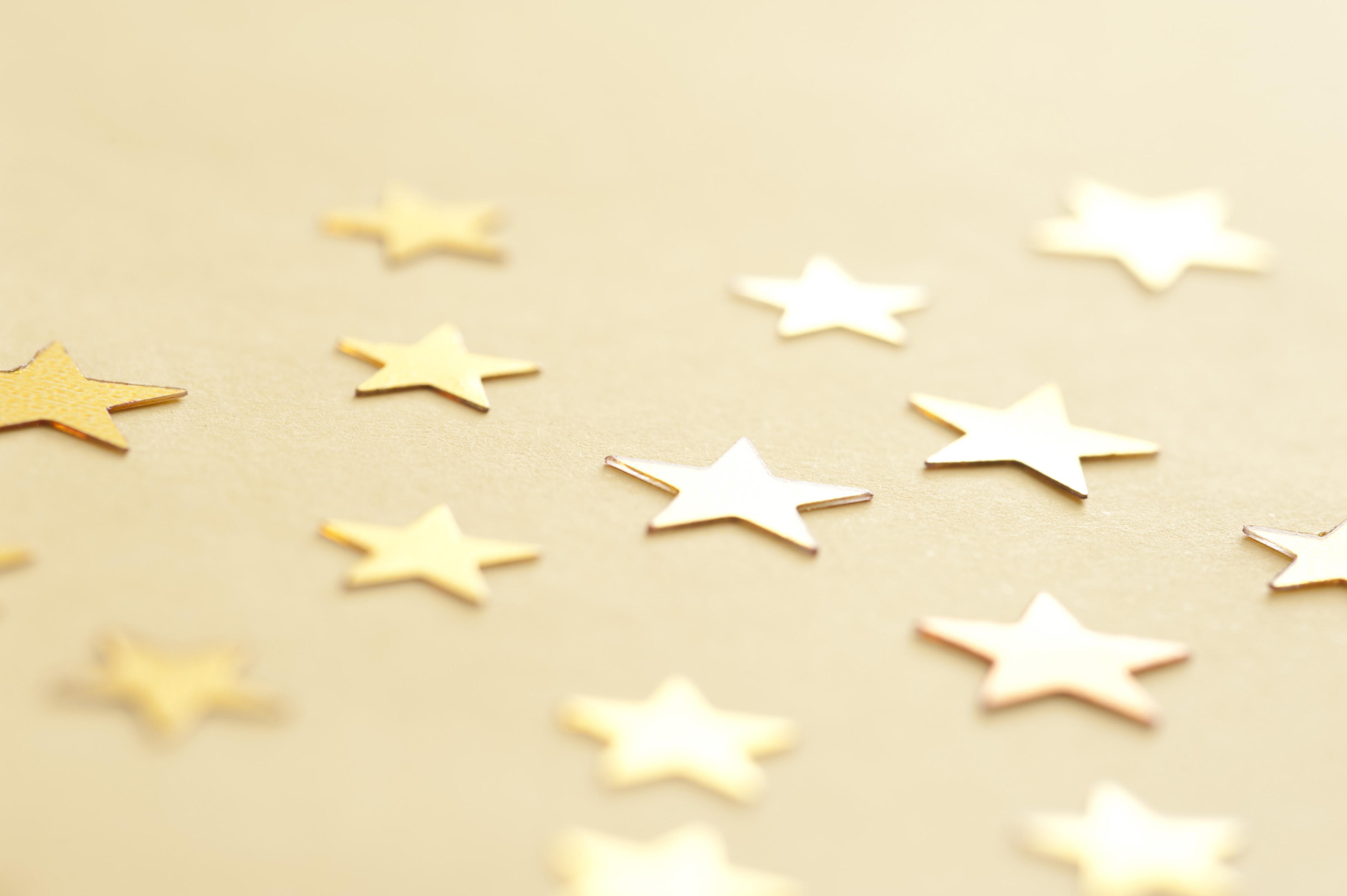 Gold Stars Scattered On Neutral Background