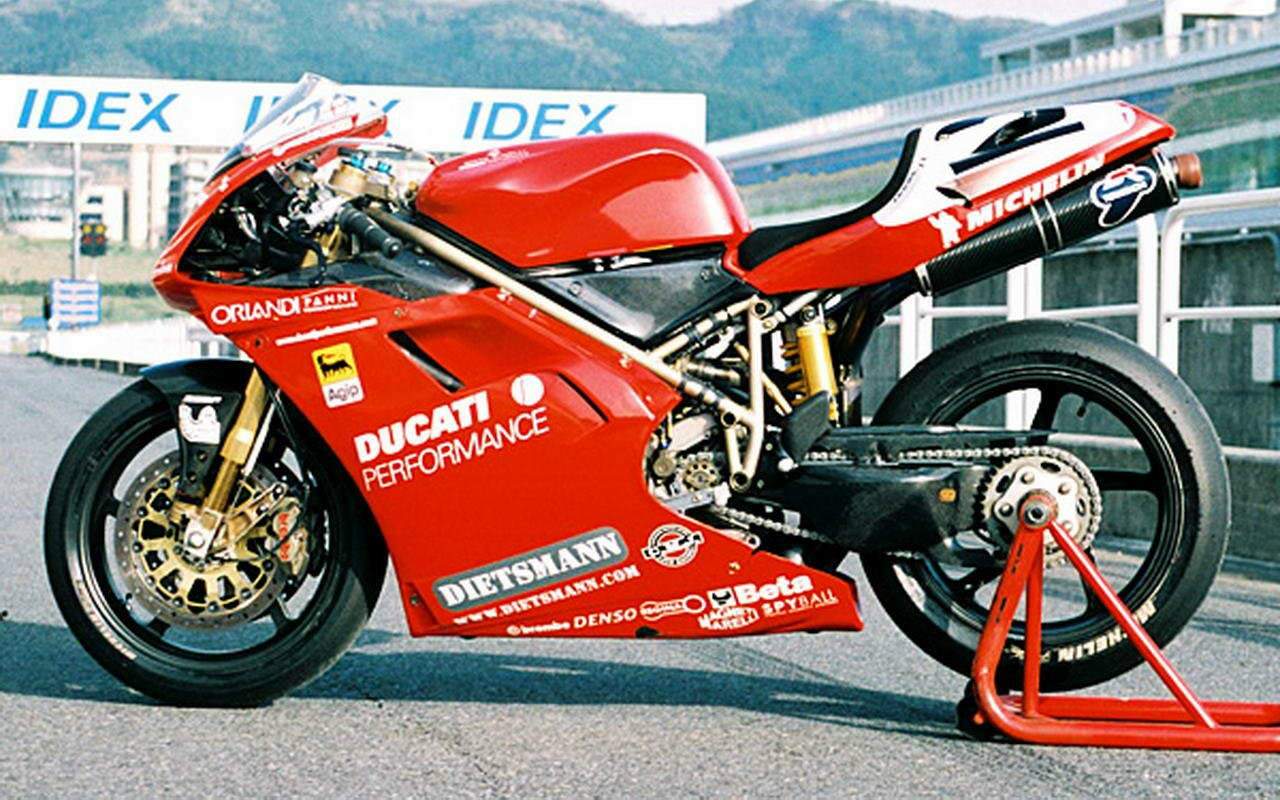 Red and white Ducati 996 racing motorcycle on a track
