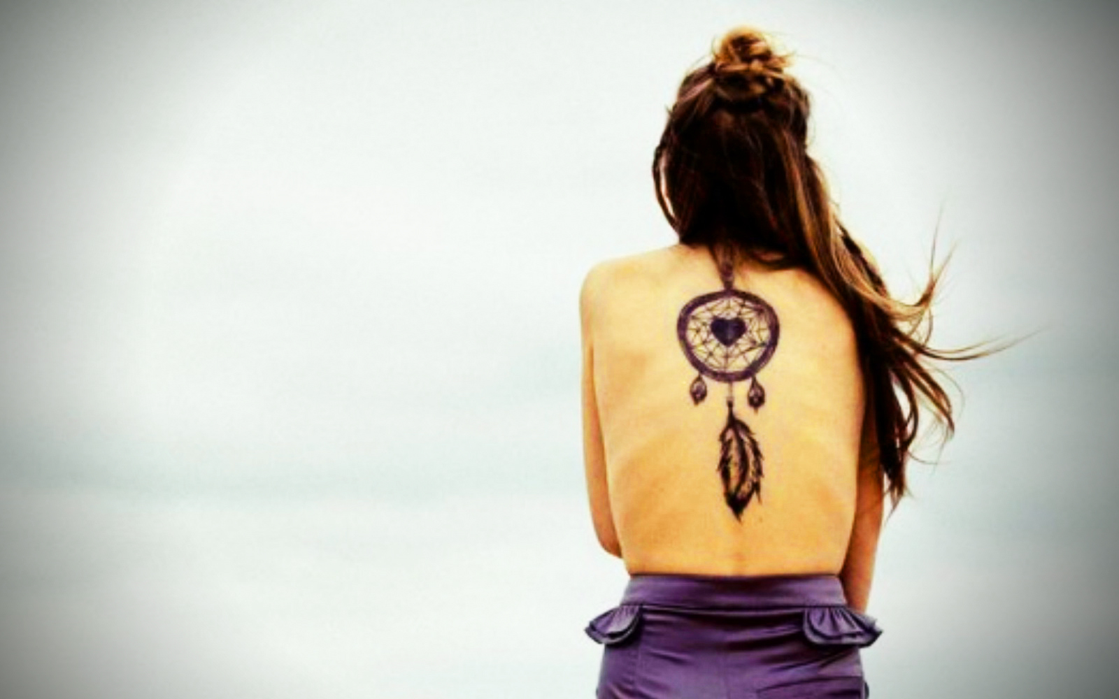 Woman with a dreamcatcher tattoo on her back