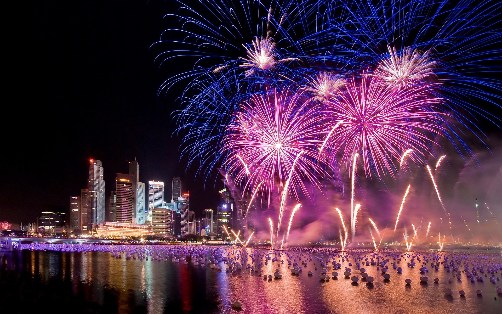 Fireworks exploding over a city skyline during New Year's Eve celebrations