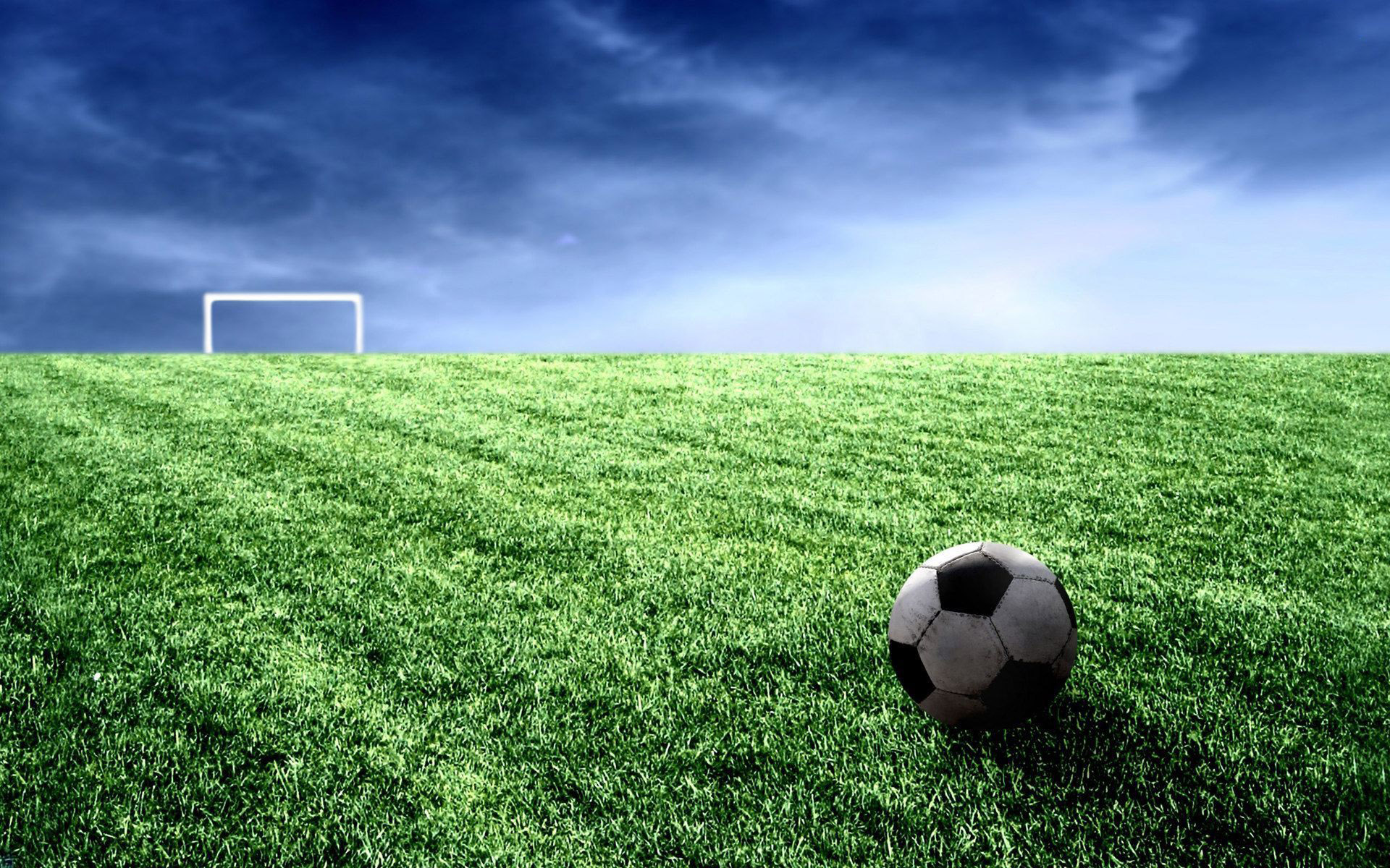 A classic black and white soccer ball sits on a lush green field, with a goalpost in the distance under a dramatic sky. Perfect for soccer enthusiasts