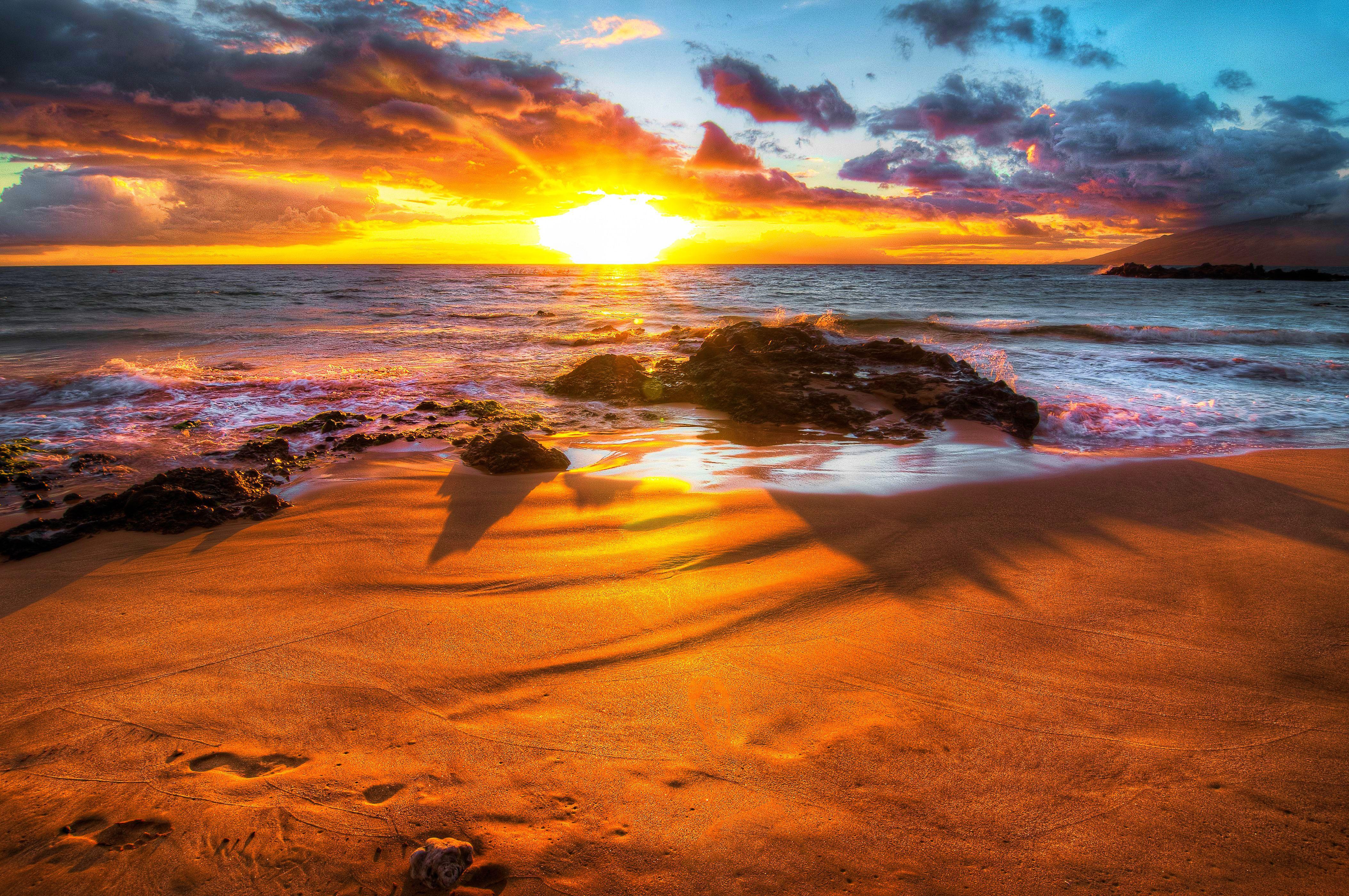Golden sunset over a tropical beach with footprints in the sand
