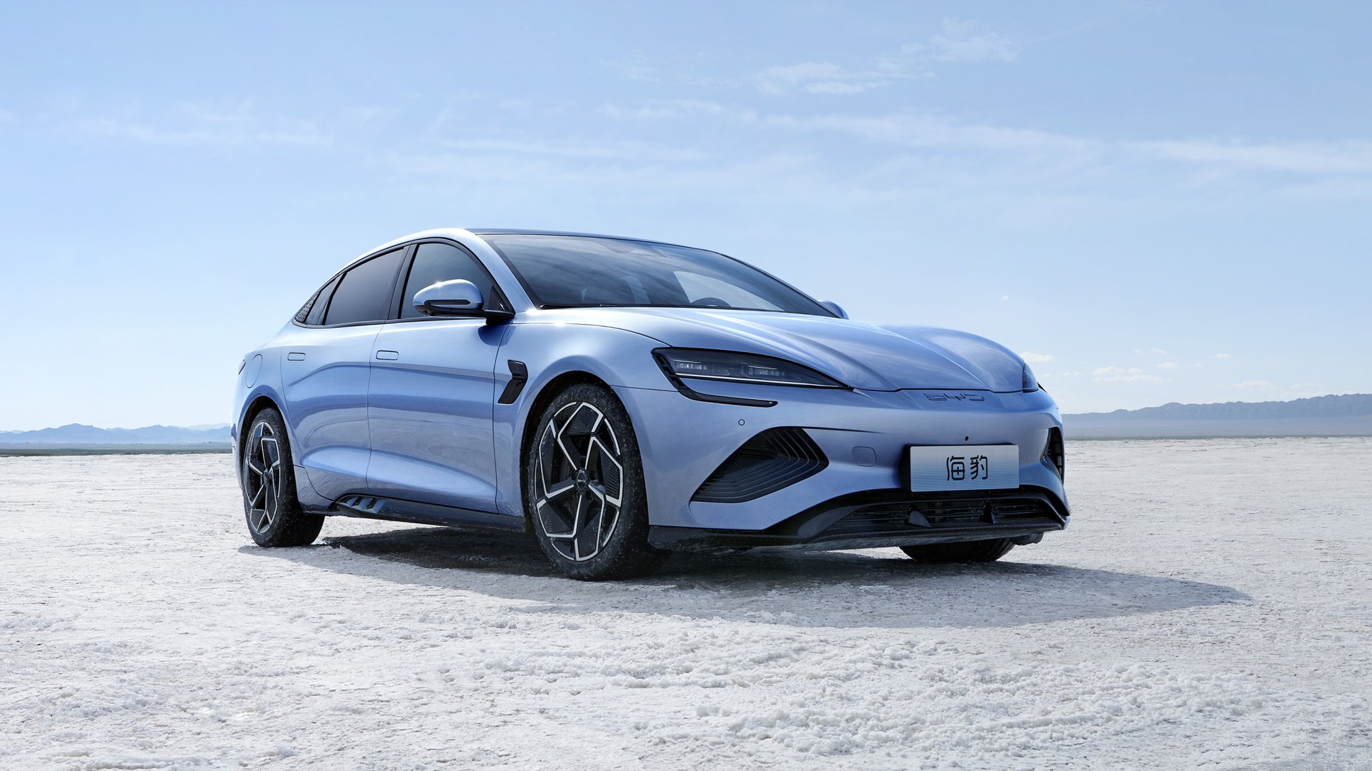 A sleek, light blue BYD Seal electric sedan parked on a vast salt flat, showcasing its modern design and sporty profile against a clear sky backdrop