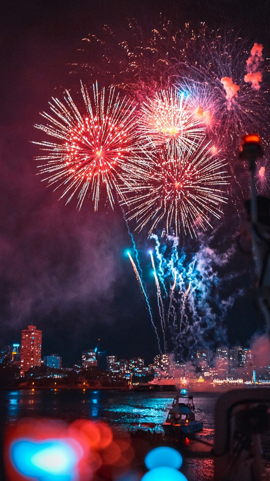 Fireworks light up the night sky over a city skyline during New Year's Eve celebrations