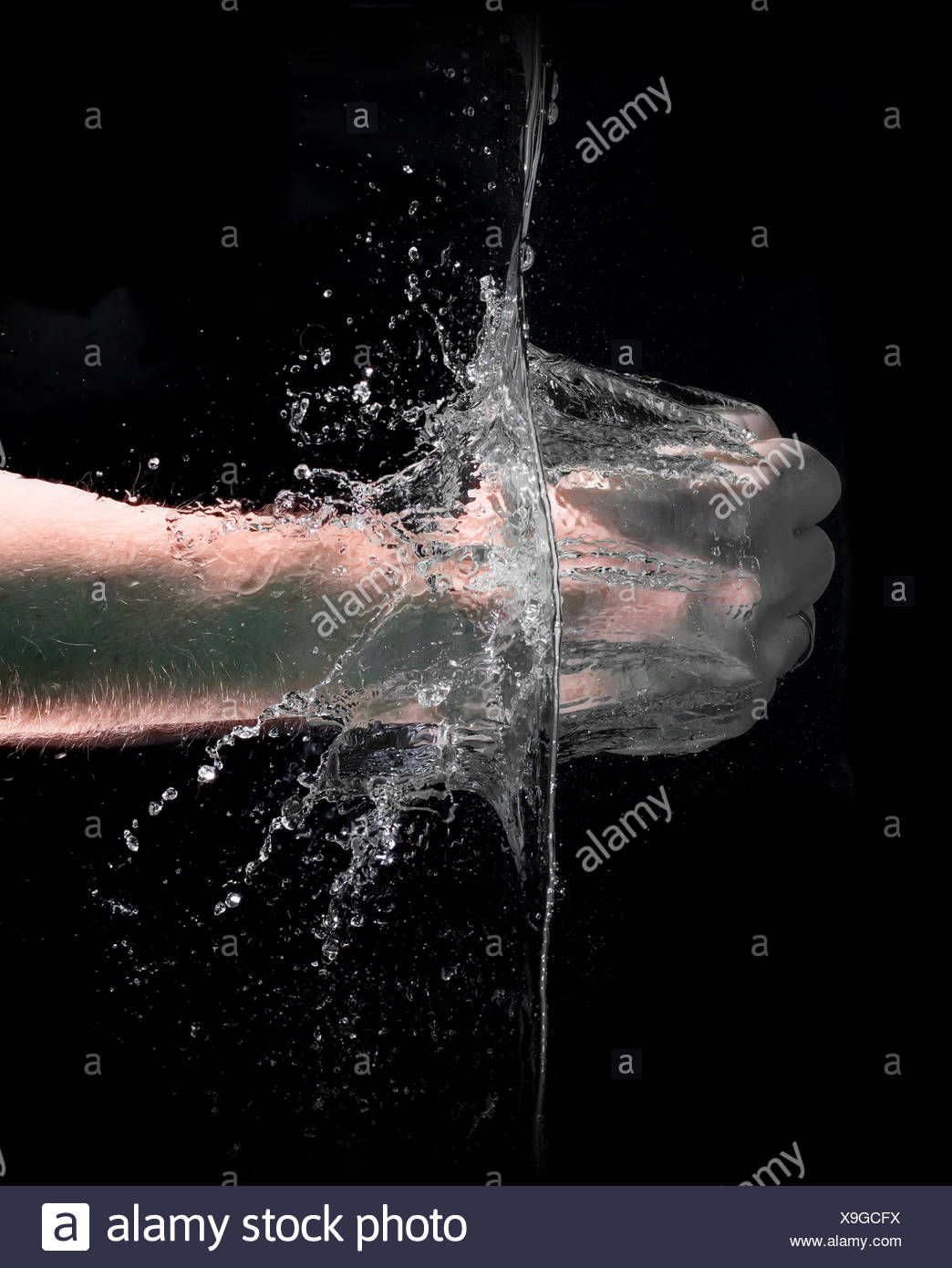 Fist Punch Into Water With Big Splashes On A Black Background