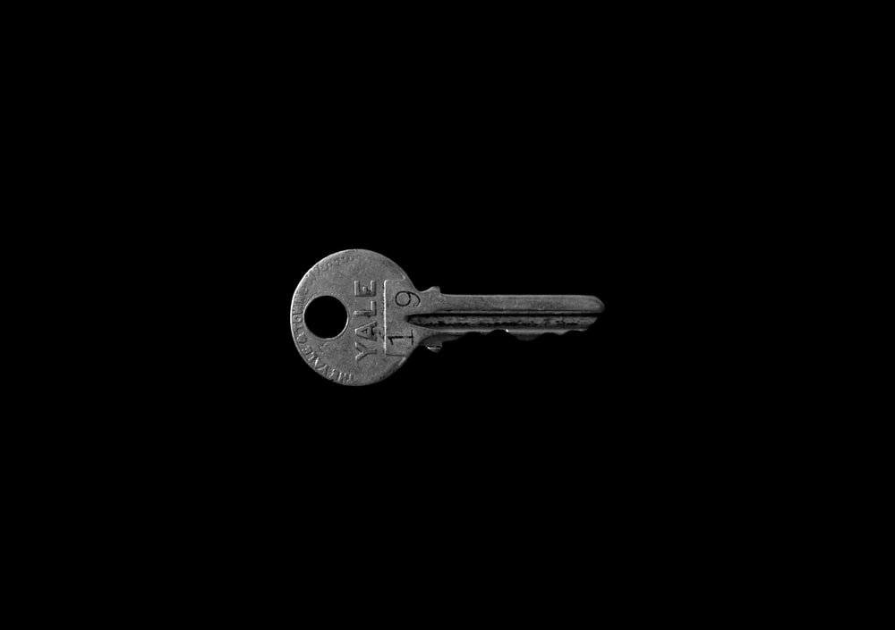 Closeup Photo Of Yale Key Against Black Background