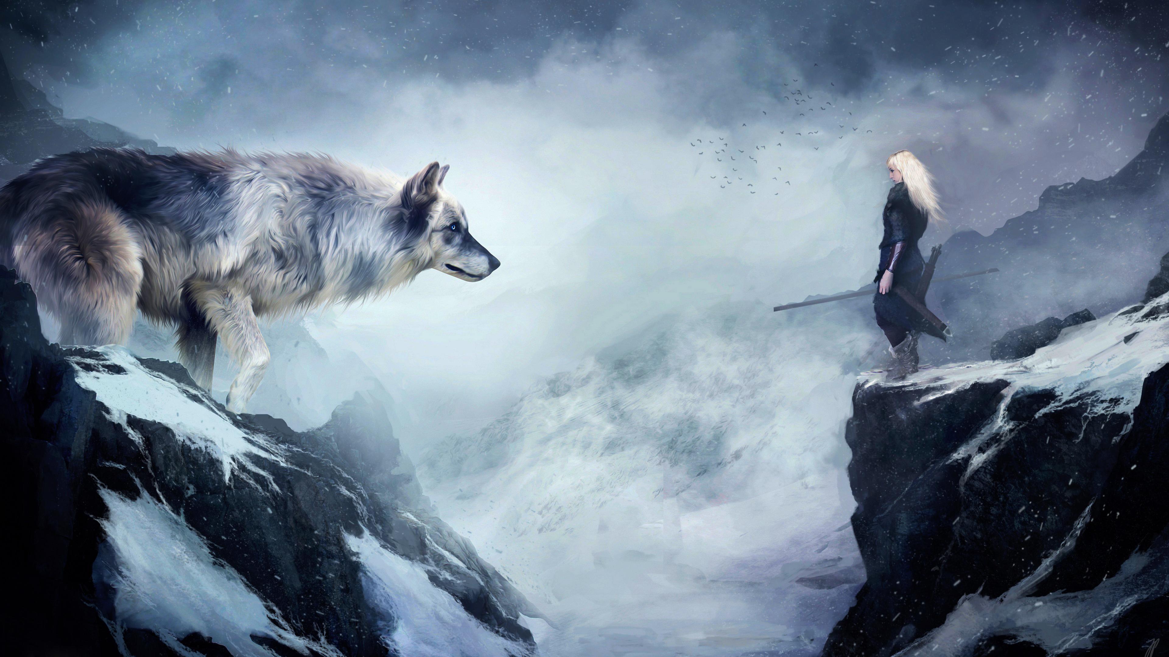 A woman with long blonde hair stands on a snowy cliff, facing a large grey wolf across a misty chasm in this 4k fantasy wallpaper