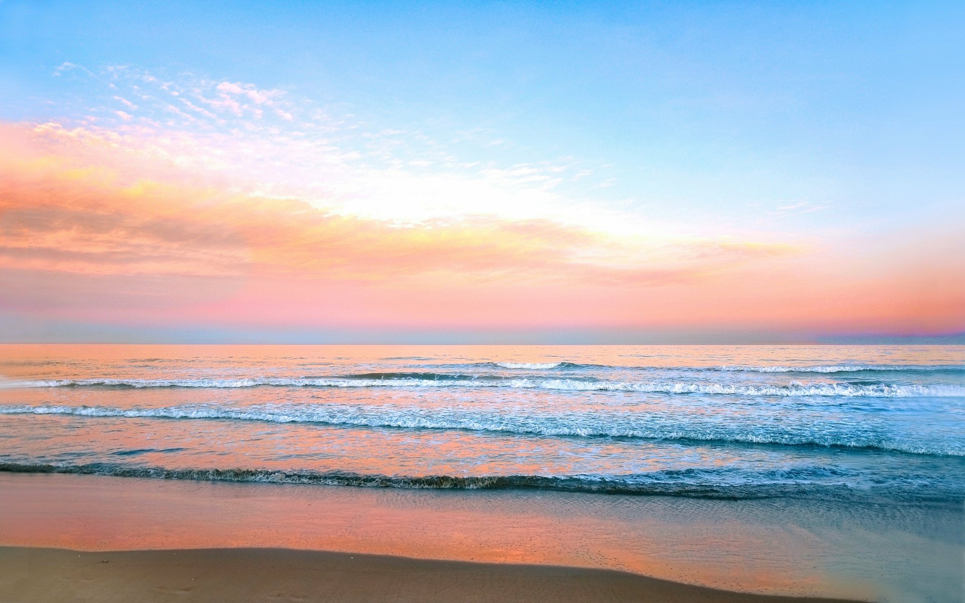 A breathtaking 4k wallpaper capturing the serene beauty of a sunset over a tranquil ocean. The soft pastel hues of the sky blend seamlessly with the gentle waves lapping at the sandy shore, creating a truly captivating scene