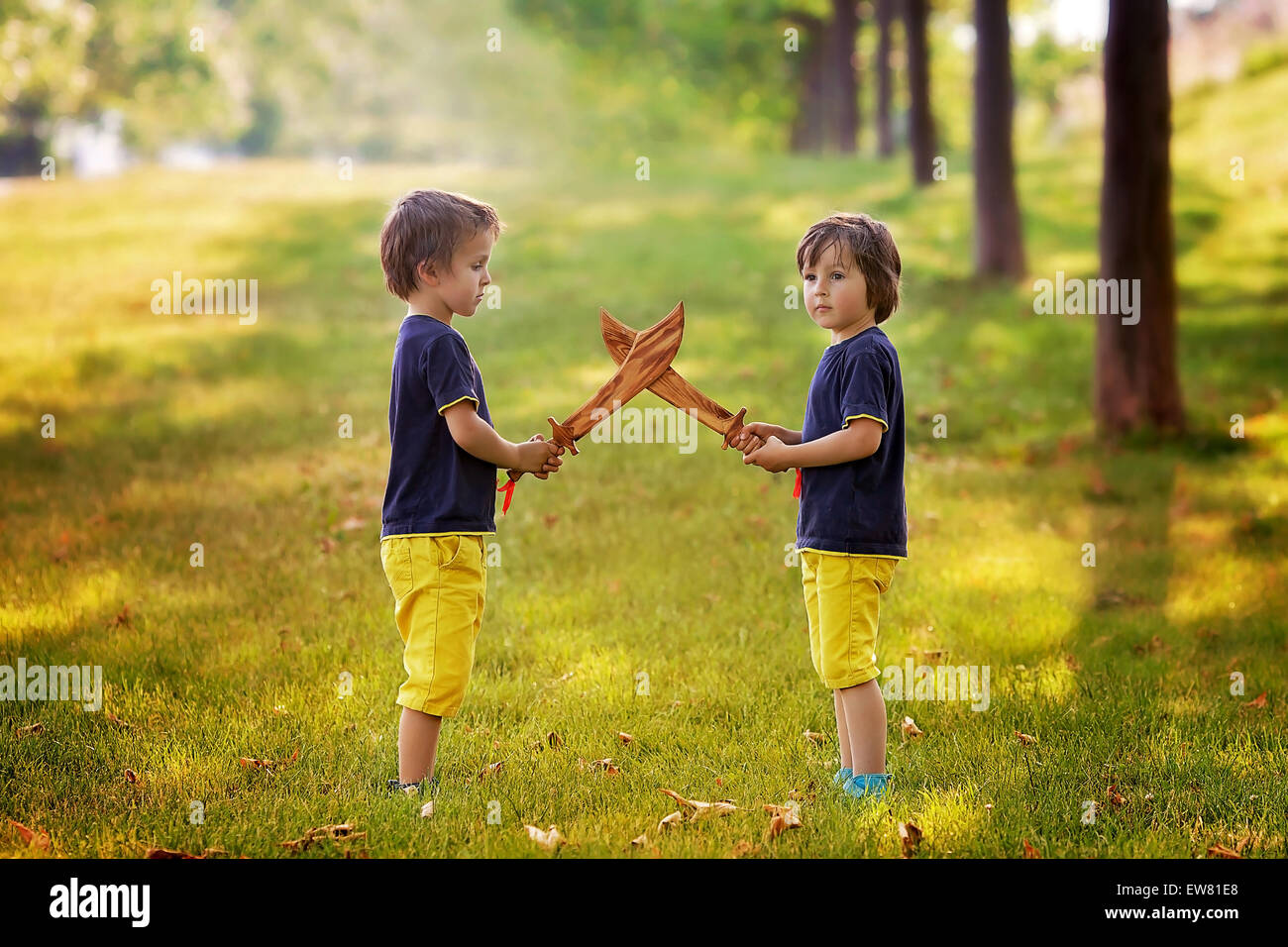 Two Little Boys Holding Swords Glaring With A Mad Face At Each
