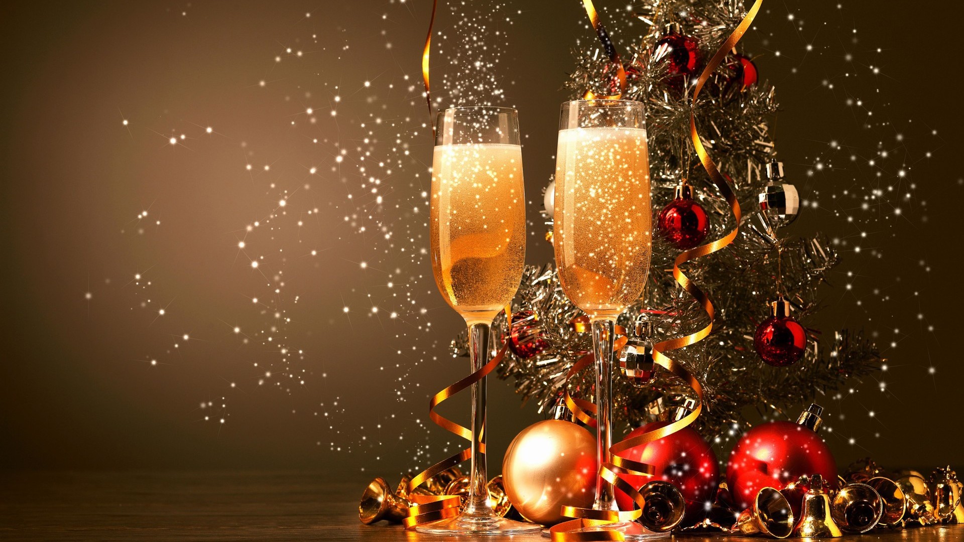 Two champagne flutes filled with bubbly, festive decorations, and a backdrop of sparkling snow create a cheerful New Year's Eve scene