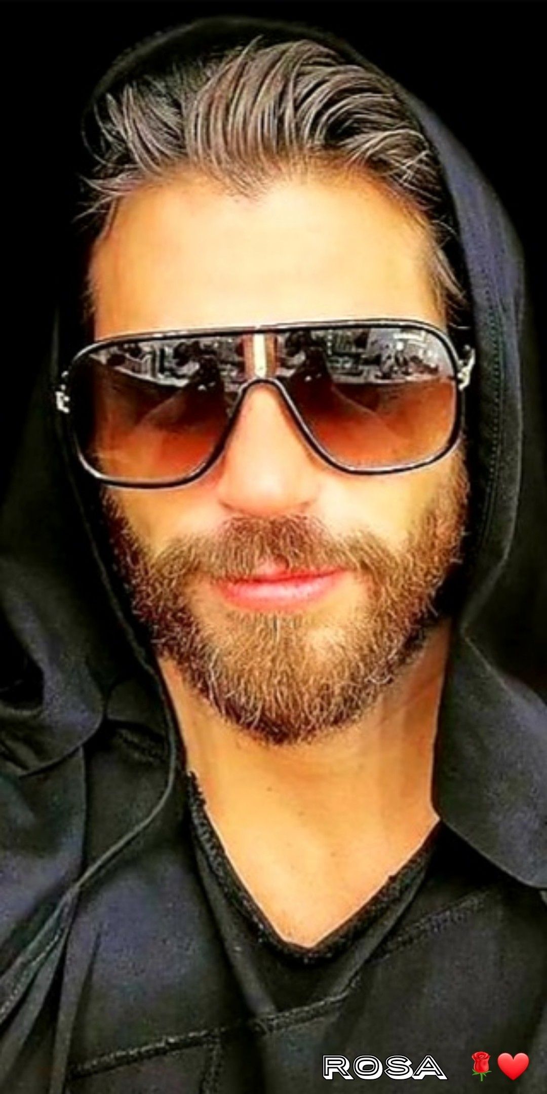 A man with a beard and sunglasses wearing a hooded sweatshirt