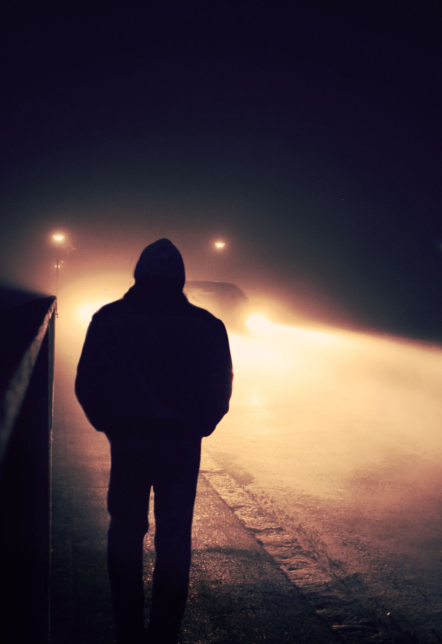 Silhouette Of A Man Walking Down The Street On Foggy Night