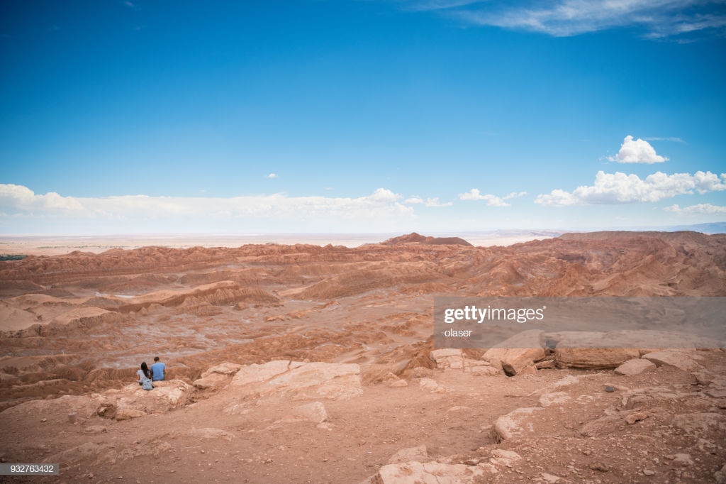 Couple On Mountaintop Together Looking At Over Moon Valley In