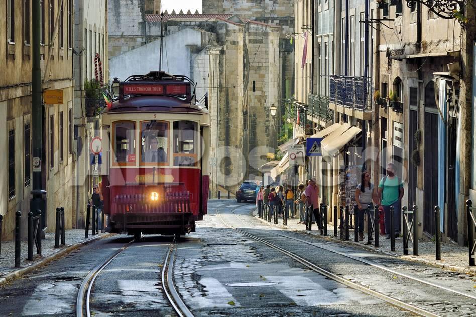 A Tramway In Alfama District With The Motherchurch Se Catedral