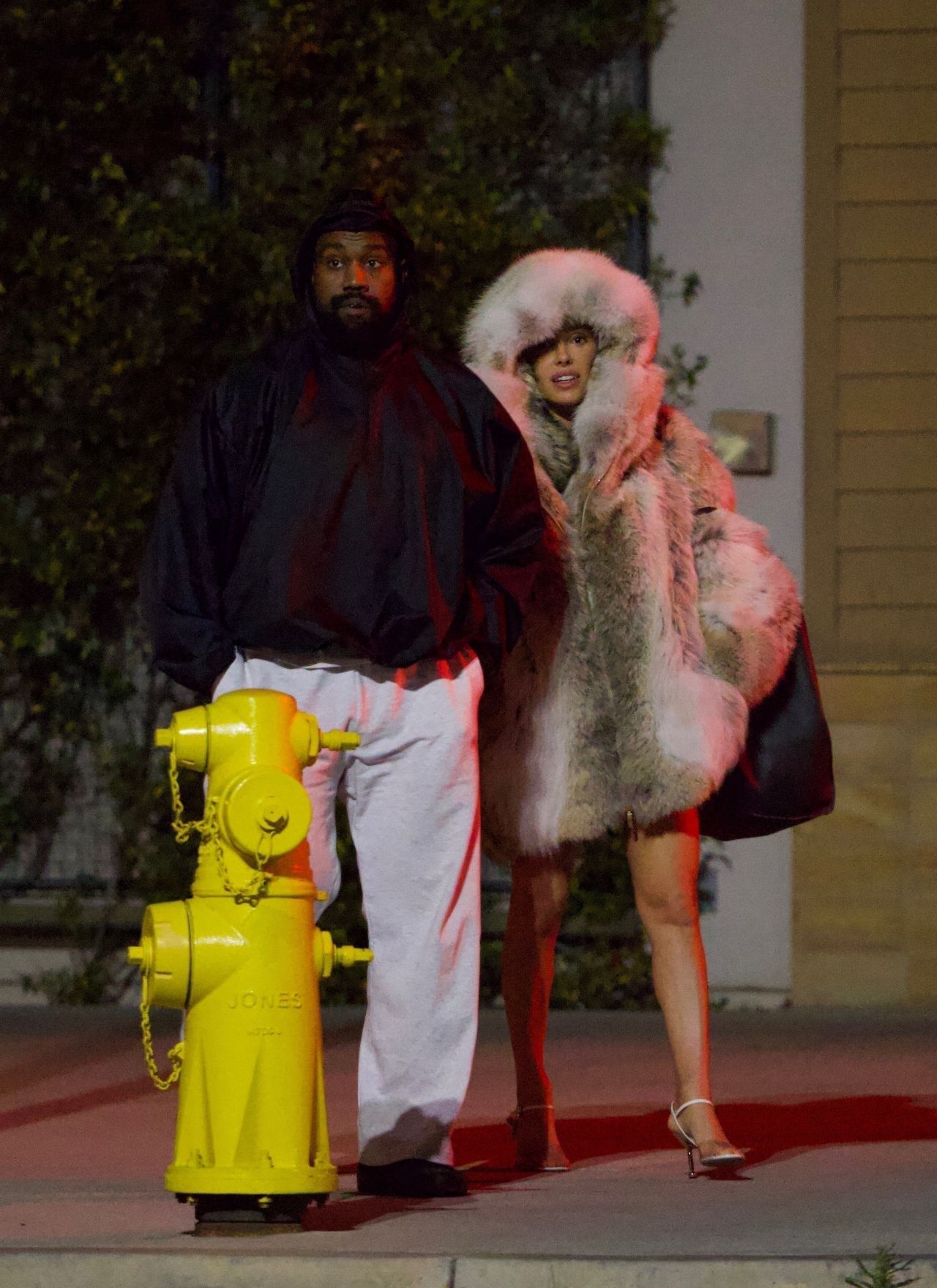 Kanye West and Bianca Censori walking together at night