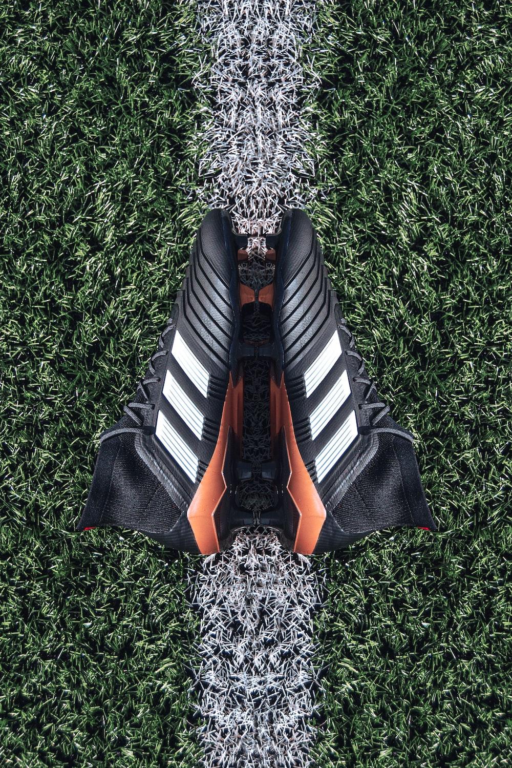 Pair Of Black Adidas Cleats On Grass Field Photo