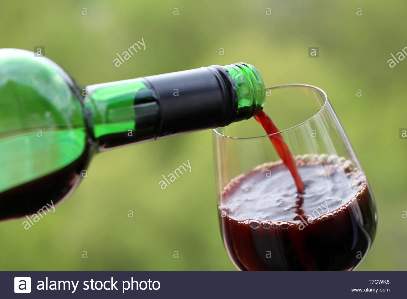 Red Wine Pouring From The Bottle Into Glass Green Nature