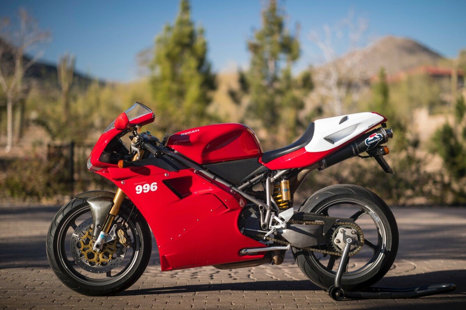 Red and White Ducati 996 Motorcycle Parked on a Brick Driveway