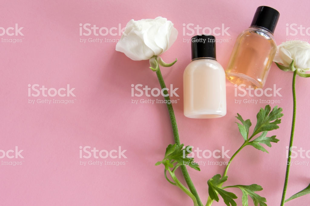 Top Of Cosmetic Products And Delicate Flowers On Pink