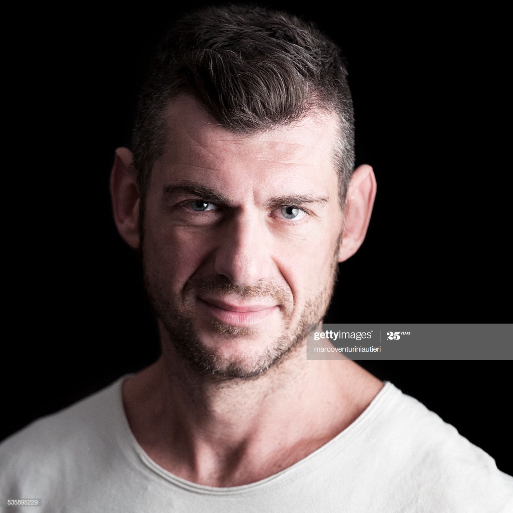 Headshot Of Serene Man In White Tshirt Black Background High Res