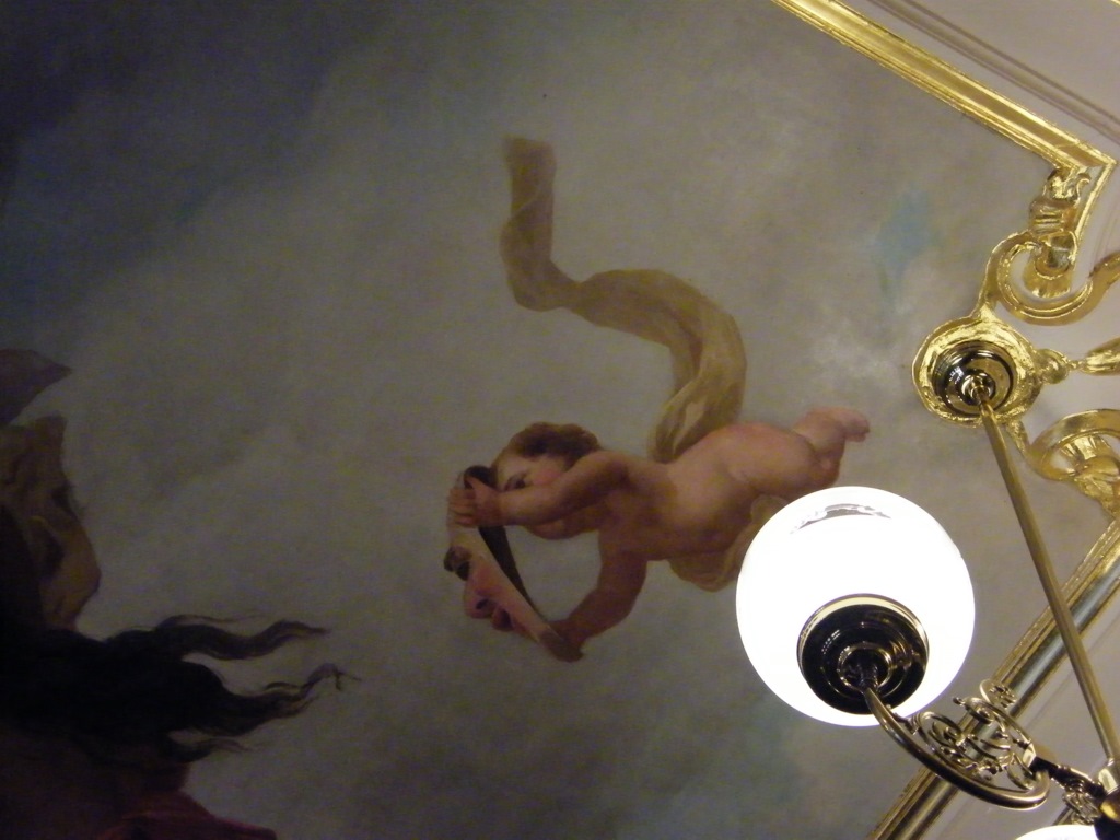 This Close Up Of The Ceiling Mural Shows Cherub With A Mask