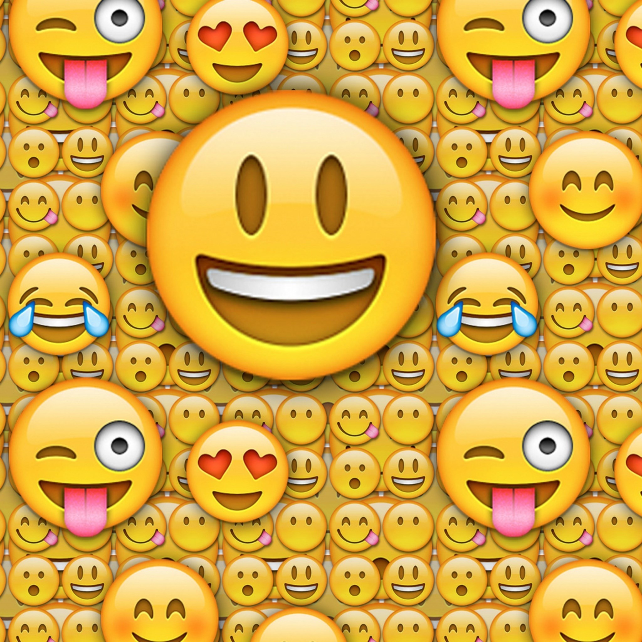A vibrant wallpaper featuring a large, smiling emoji at the center, surrounded by a repeating pattern of smaller emojis with various expressions, including winking, heart eyes, and tears of joy