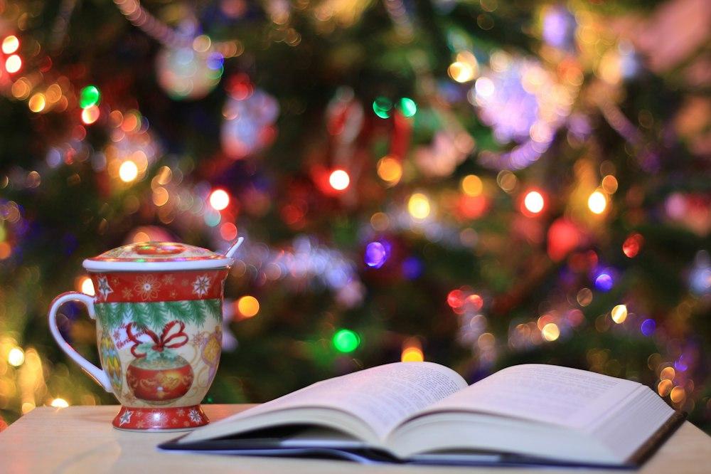 Red And Green Ceramic Mug Beside Book Photo Christmas Image