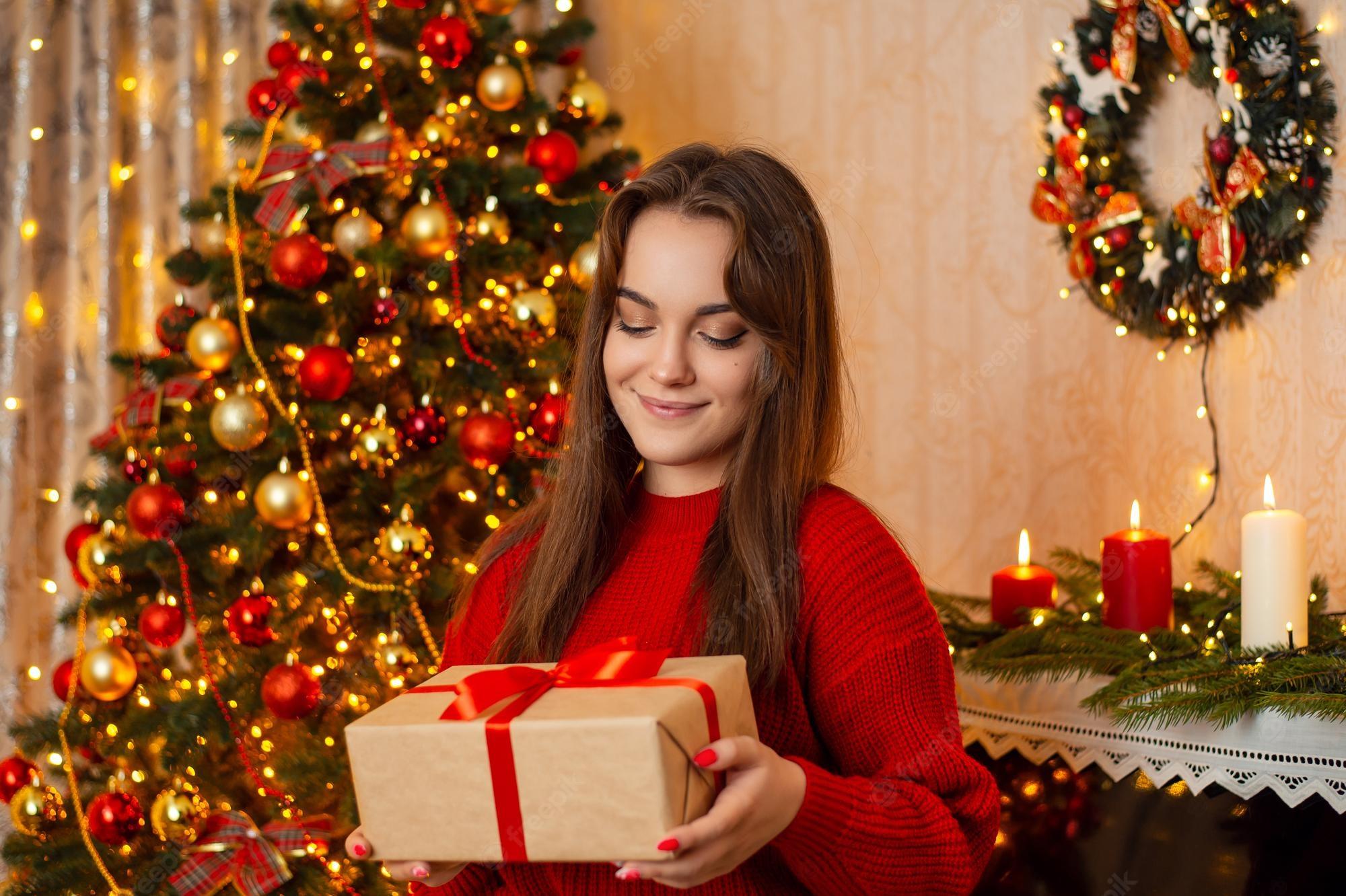 Premium Photo Young Smiling Woman Picks A Box With Christmas