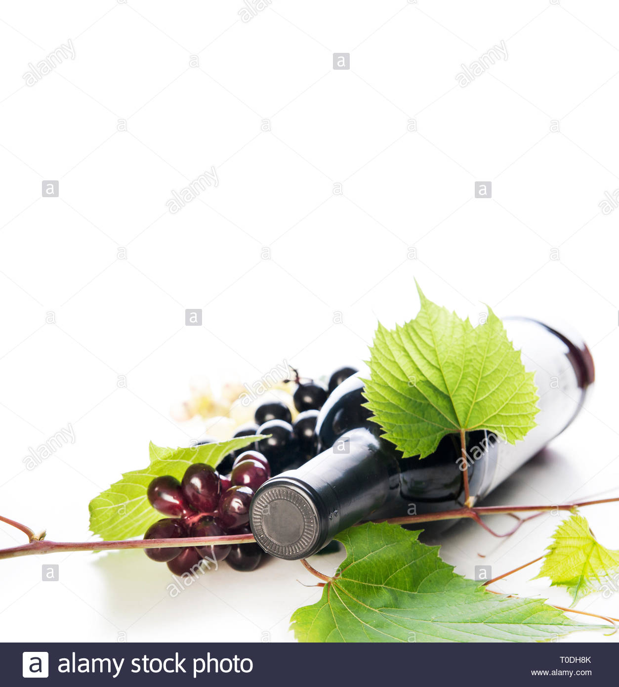 Bottle Of Luxury Red Wine And Grape Vine Frame Isolated Over White