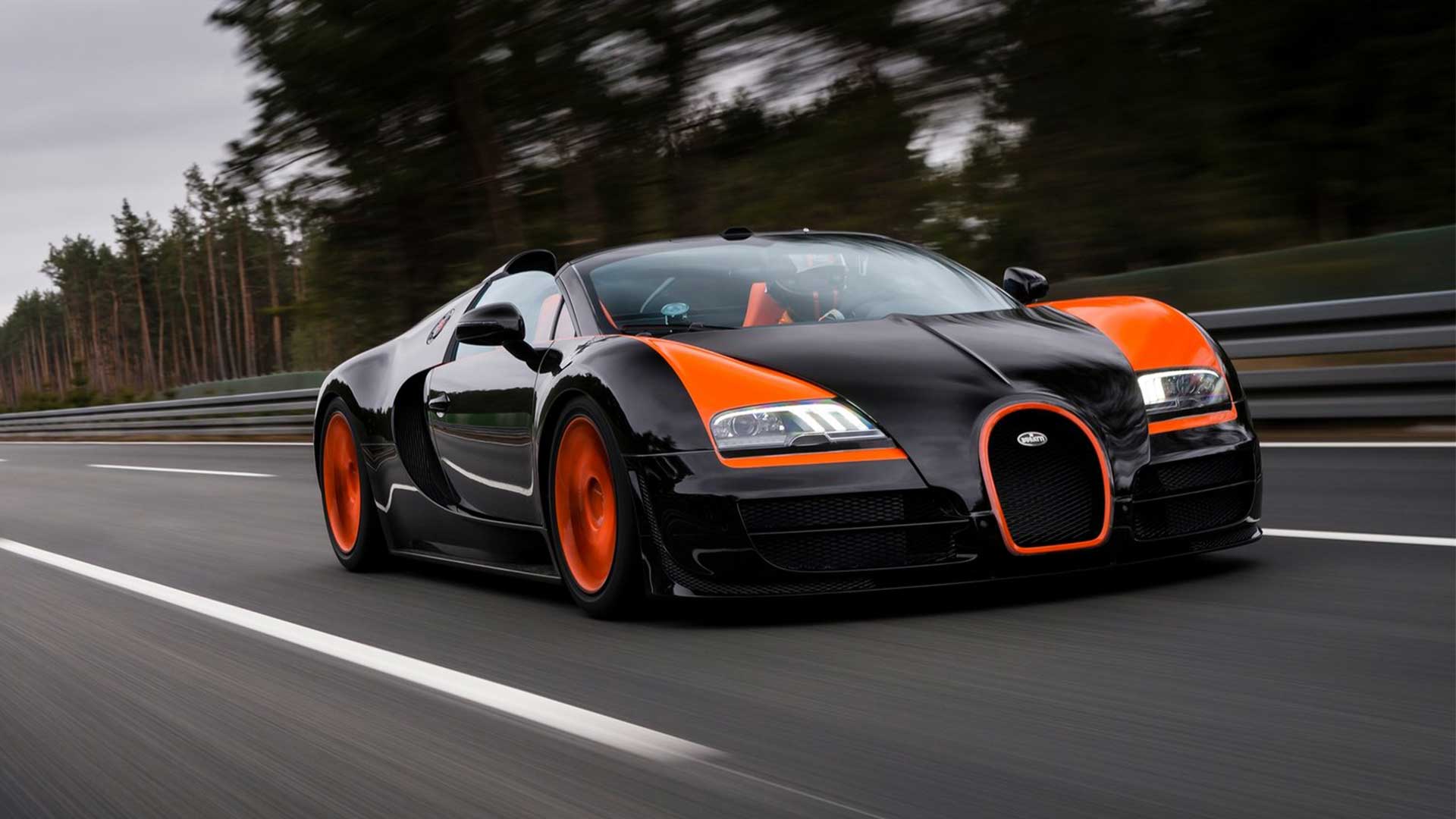 Black and Orange Bugatti Veyron Grand Sport Vitesse in motion on a racetrack