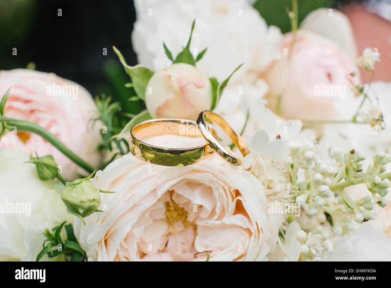 Golden Wedding Rings And A Beautiful Bouquet Of Roses