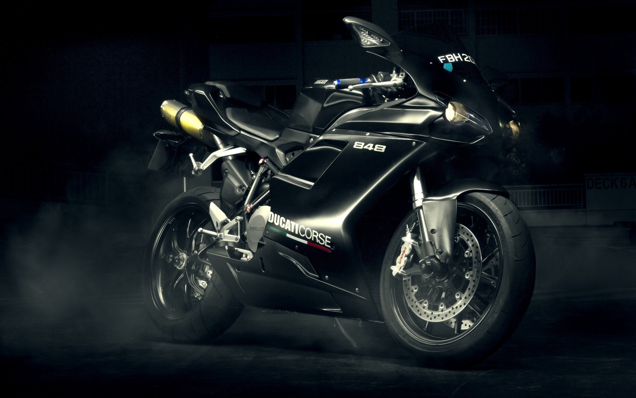 A sleek black Ducati 848 sportbike parked in a dark setting, highlighting its powerful design and dark aesthetic
