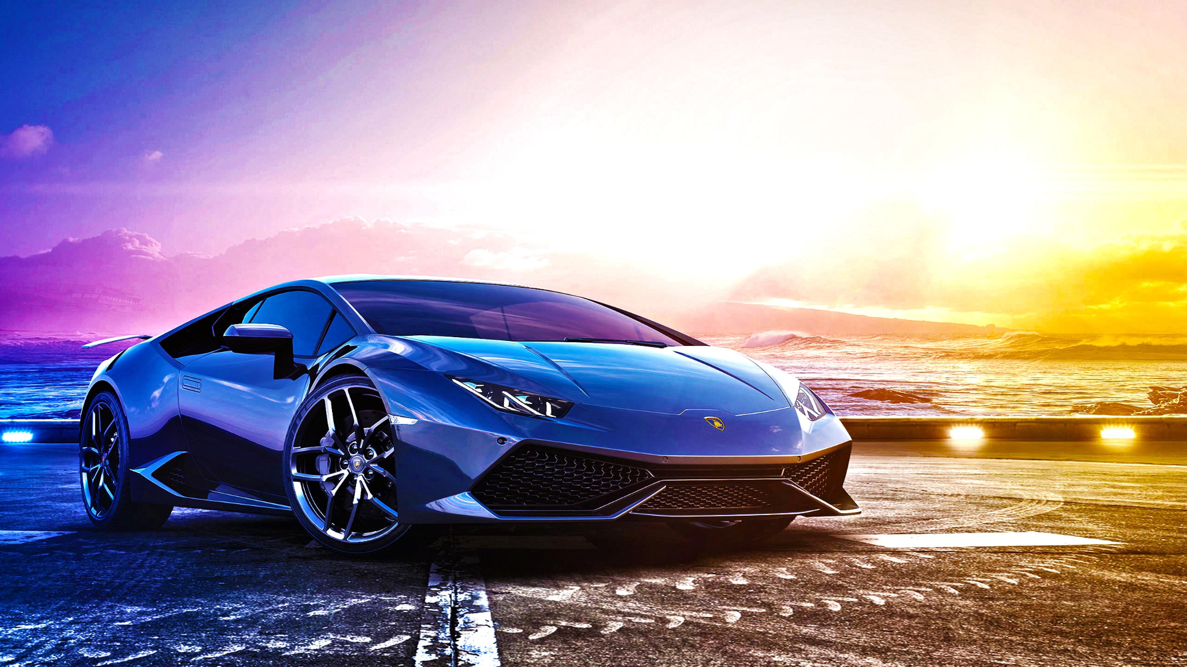 Blue Lamborghini Huracán parked by the ocean at sunset