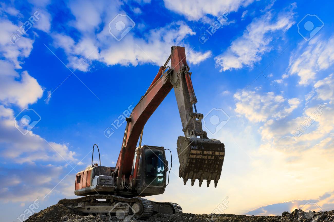 Excavator In Construction Site On Sunset Sky Background Stock