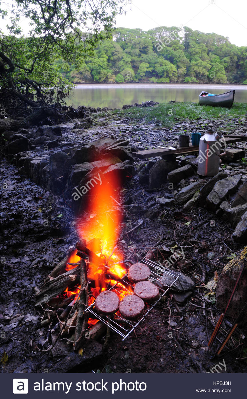 Cooking Beef Burgers On An Open Fire While Canoe Camping In The