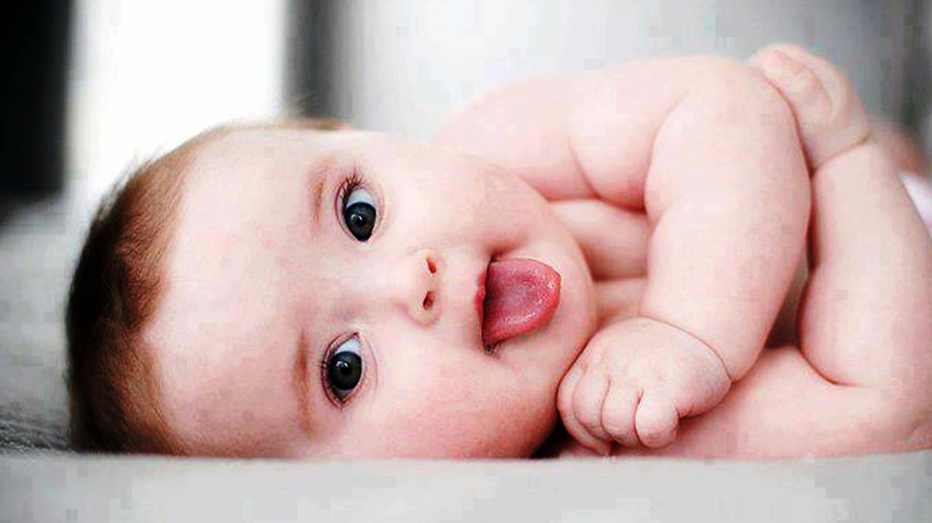 A Cute Baby Ready For Fun With His Tongue Out Wallpaper