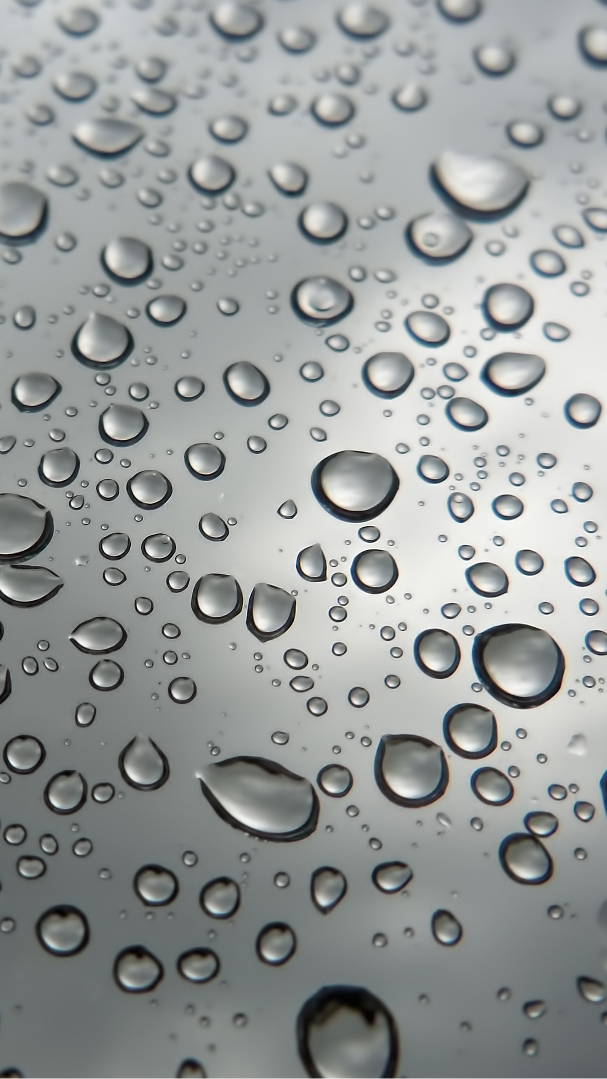 Close-up of water droplets on a smooth surface, creating a textured pattern of shimmering beads