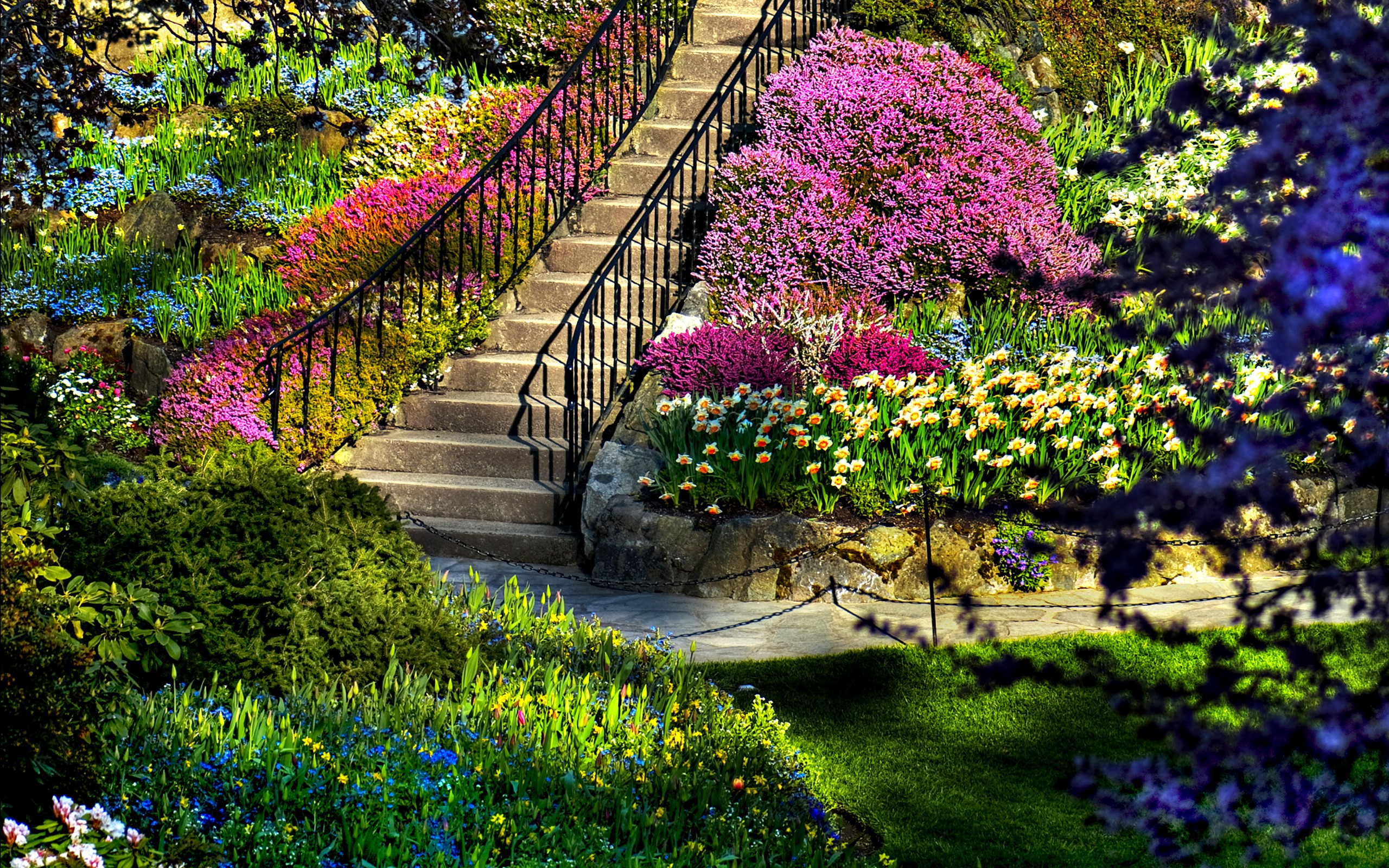 A vibrant garden scene with a stairway winding through colorful flowers and lush greenery, creating a picturesque nature background