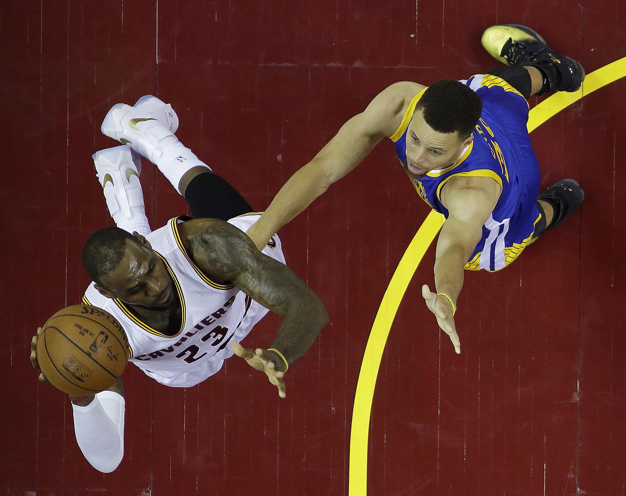 Lebron James and Stephen Curry battling for the ball during a game