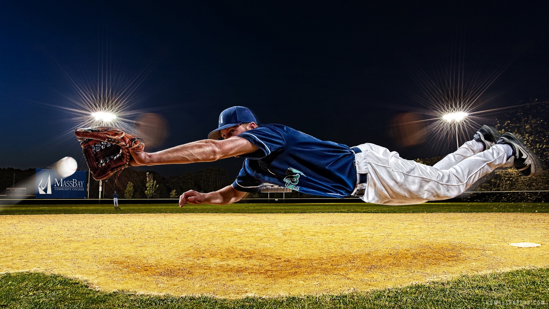 A baseball player diving for a catch on a brightly lit field