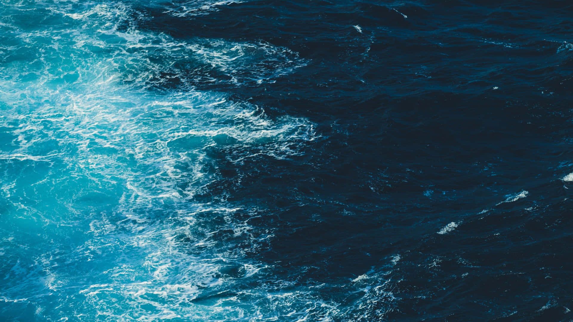 Dark blue ocean waves crashing and churning, creating a dramatic and powerful seascape