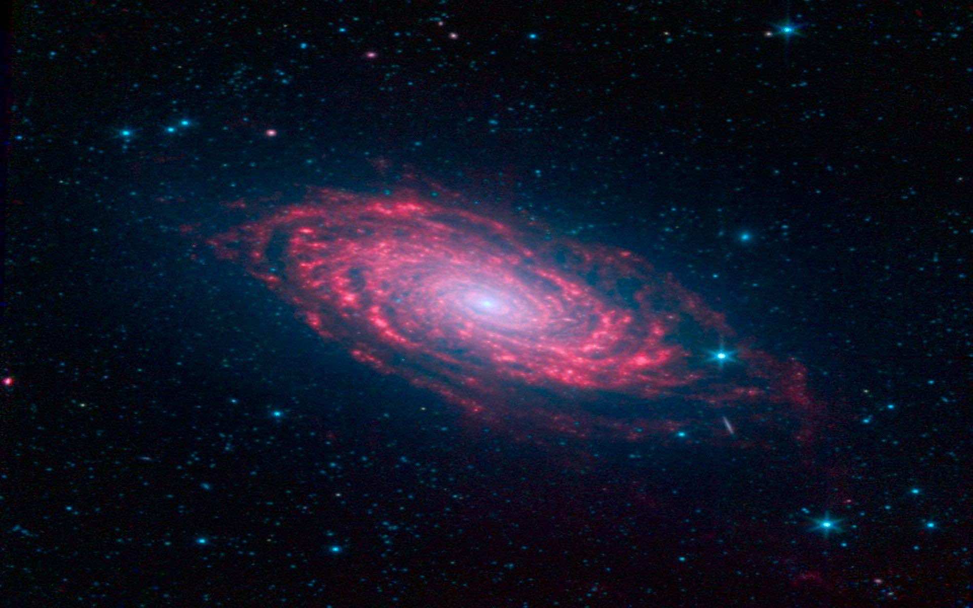 A stunning spiral galaxy with pink and blue hues, captured in a high-resolution image against a dark, star-studded backdrop. Perfect for space enthusiasts and galaxy wallpaper lovers