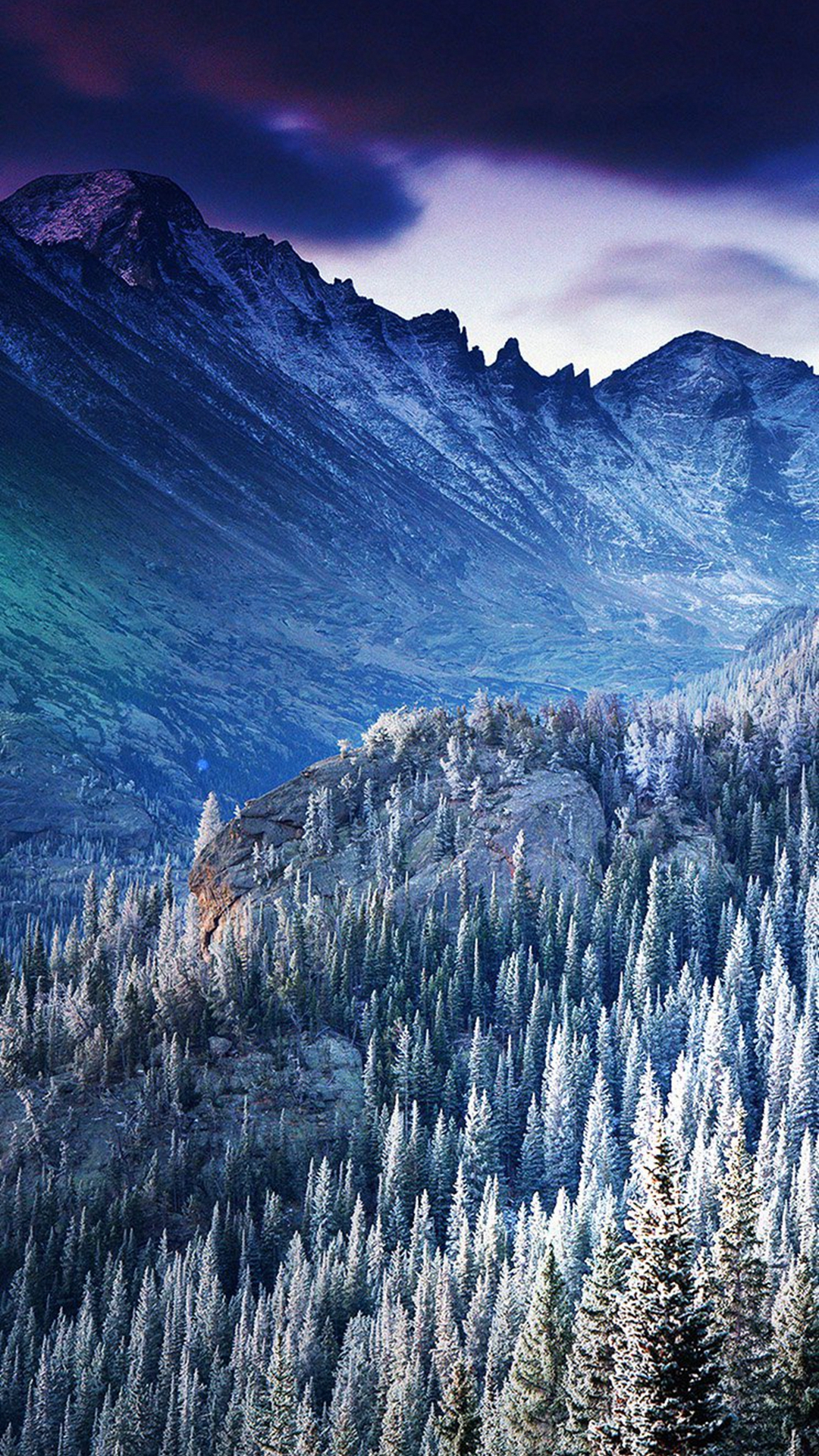 A breathtaking winter landscape with snow-covered pine trees in the foreground and majestic, snow-capped mountains in the background under a dramatic purple and pink sky
