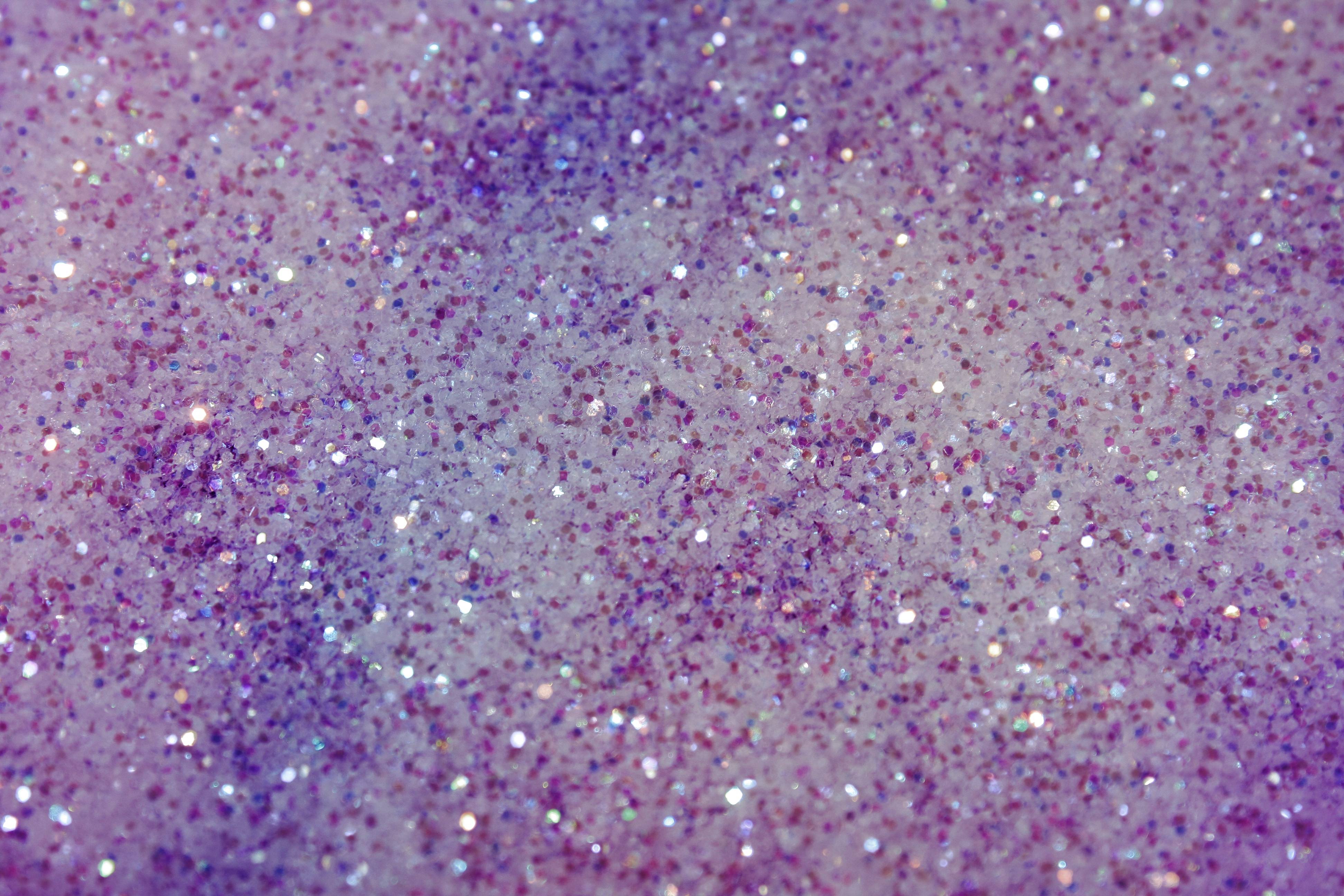 Close-up of a sparkly surface with a blend of pink and purple glitter, creating a vibrant and textured background