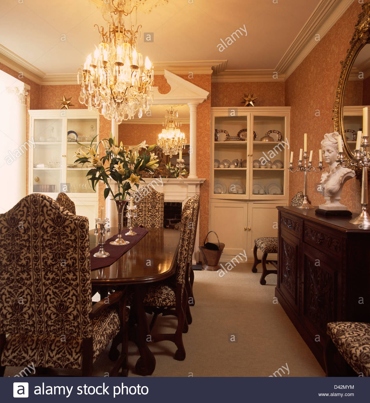 Chandelier Above Tapestry Upholstered Chairs And Mahogany Table In