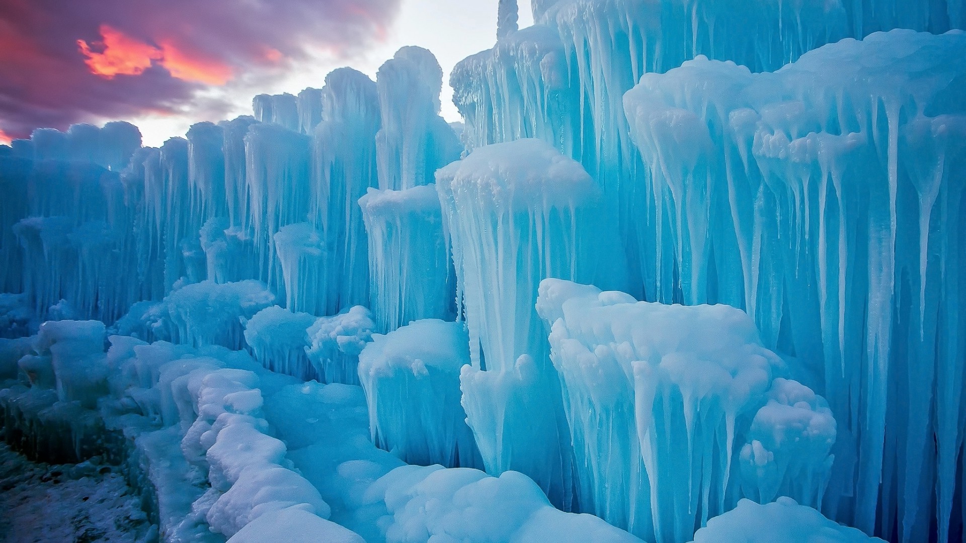A breathtaking close-up of an ice castle, showcasing the intricate patterns and vibrant blue hues of frozen water. Icicles hang in delicate formations, creating a magical winter wonderland
