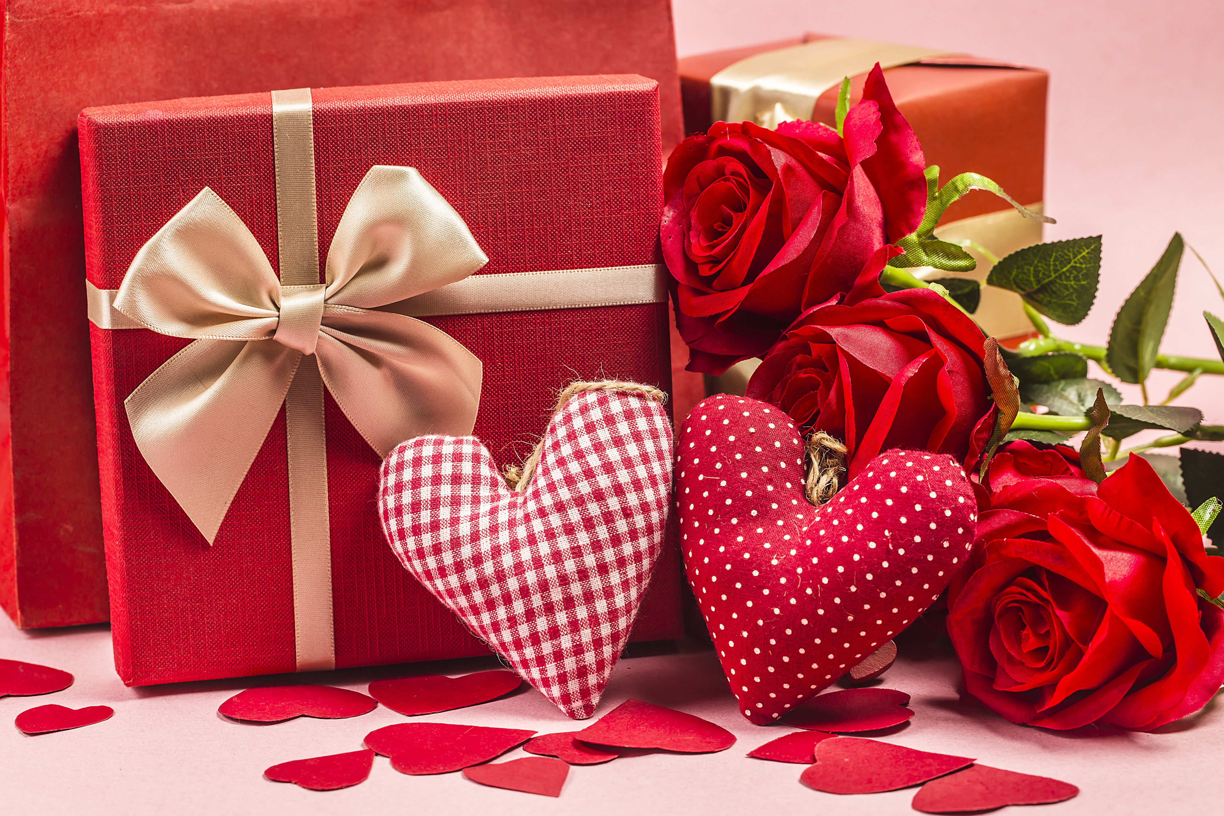 Red roses, hearts, and gift boxes arranged on a pink background. Perfect for Valentine's Day celebrations