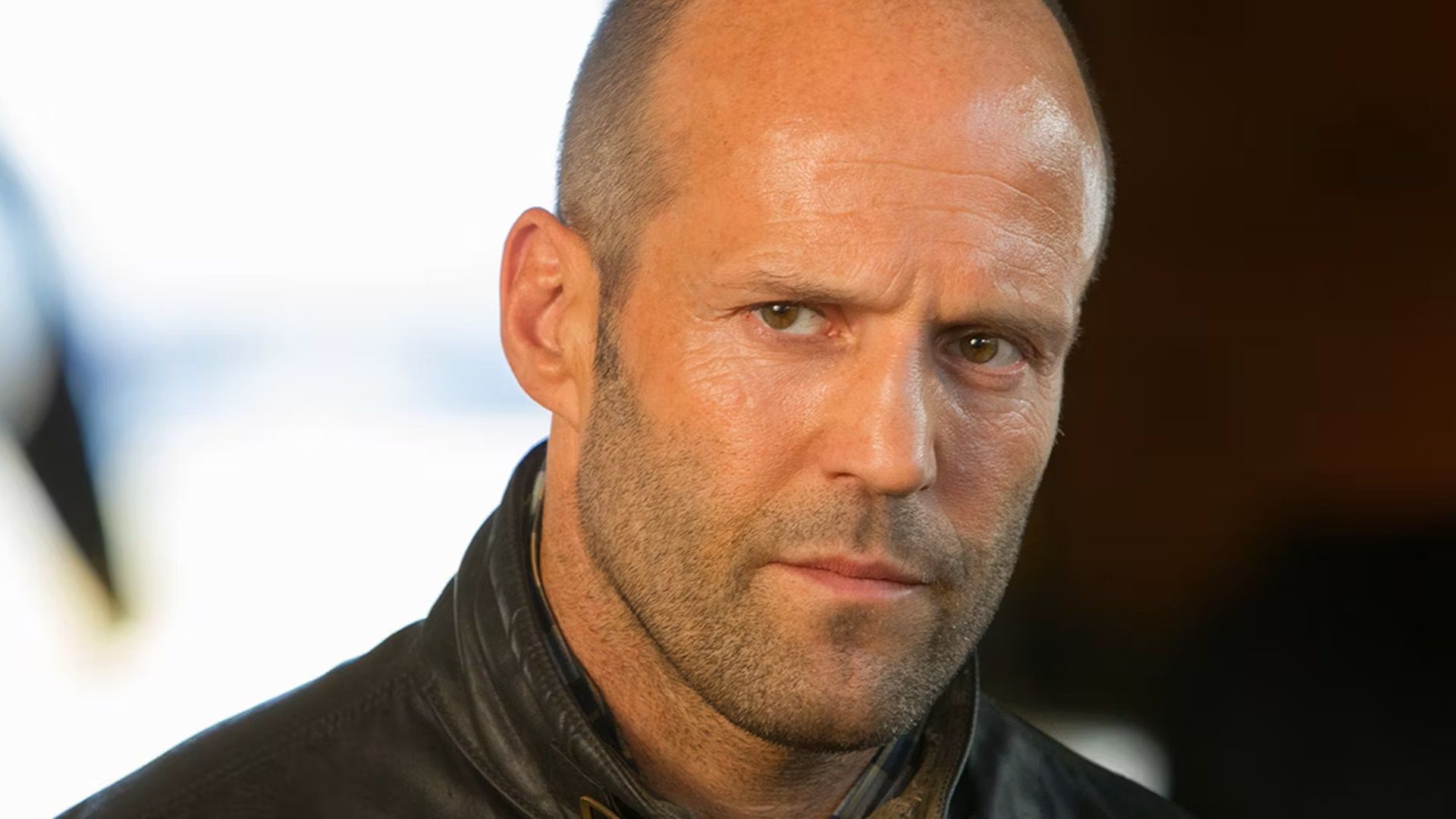 Close-up headshot of Jason Statham with a serious expression