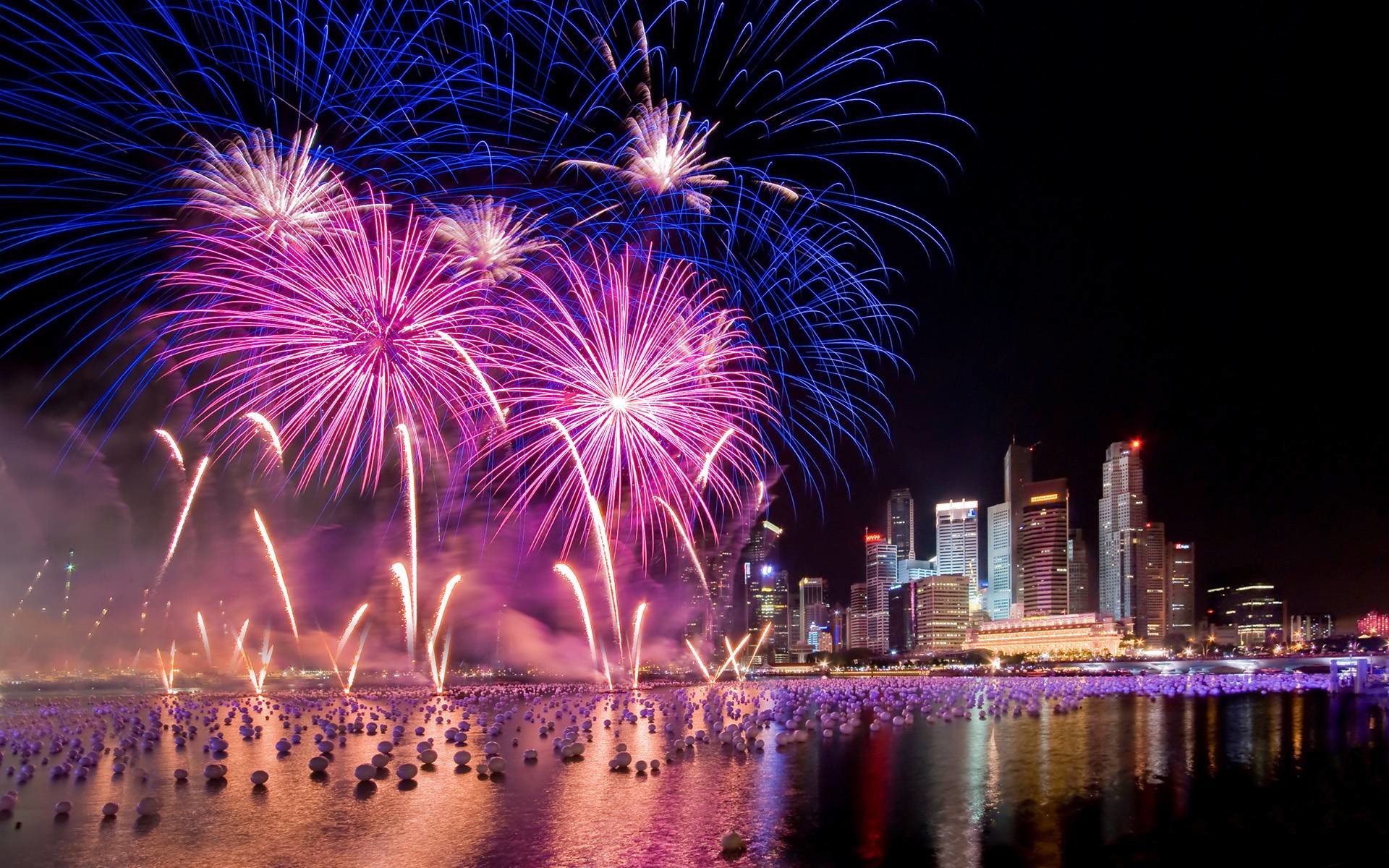Fireworks exploding over a city skyline at night, celebrating New Year's Eve